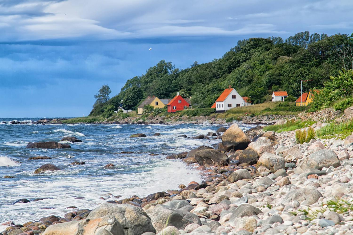 En kyststrækning med hus tæt ved havet